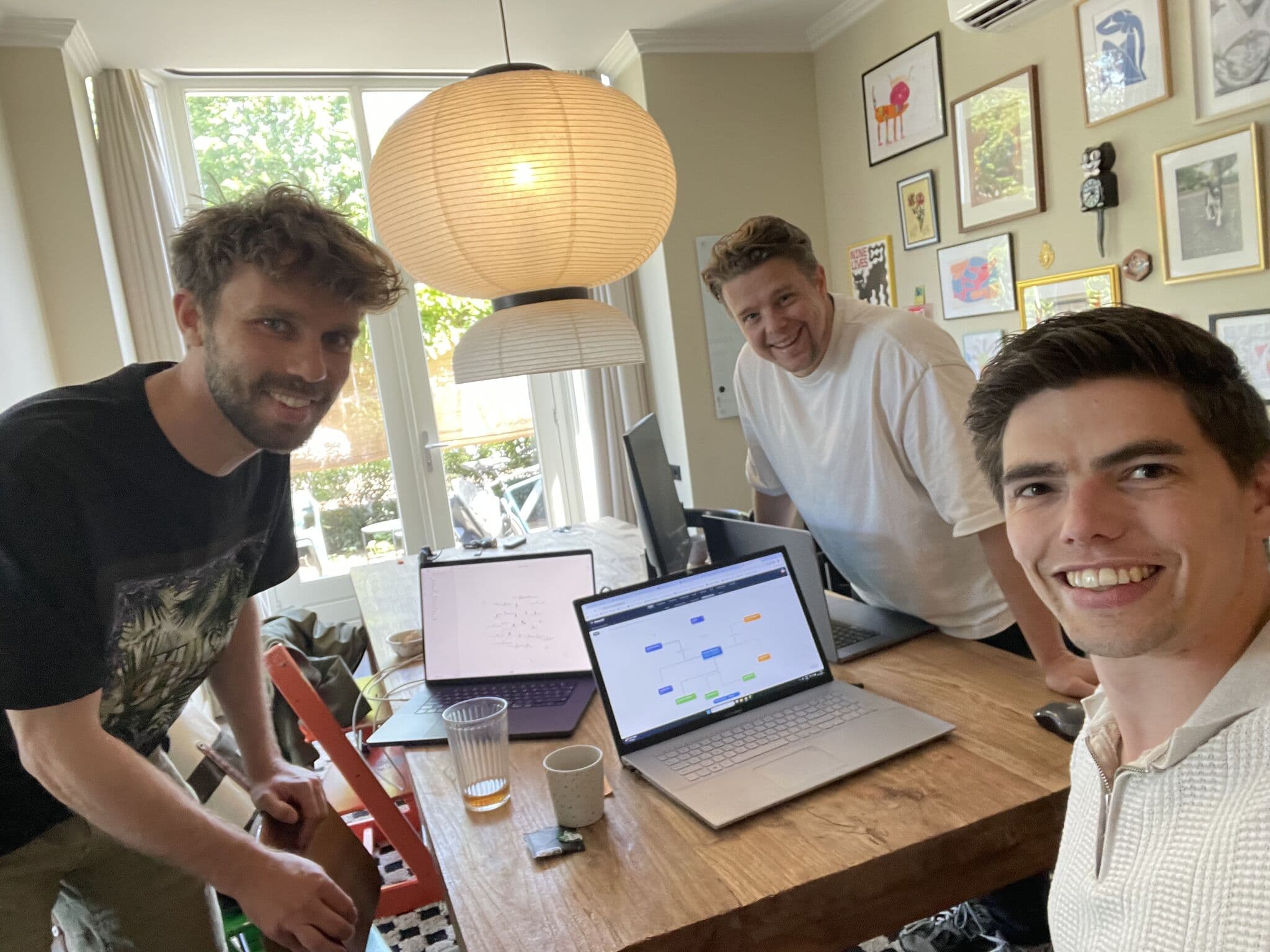Jan, Frans en Huub aan tafel achter hun laptops, met een uitgewerkte workflow op het scherm